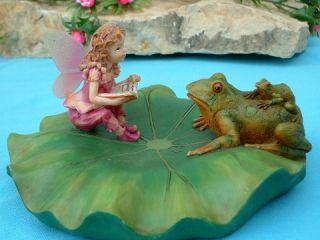 with her baby on her back, has hopped up on the lily pad to visit